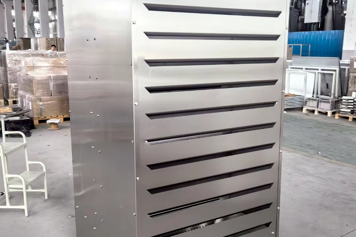 Kabinet besar dari baja tahan karat dengan kisi-kisi ventilasi horizontal.