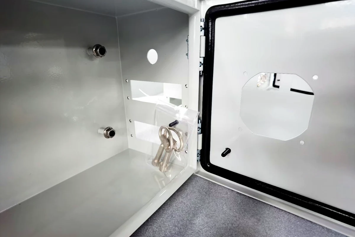 Kotak penyimpanan terbuka berbahan stainless steel yang dipasang di dinding dengan perangkat keras pintu yang terpasang.