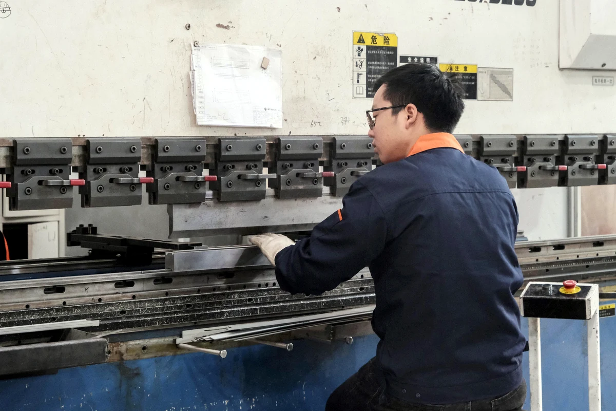 Operator bending sheet metal at a press brake